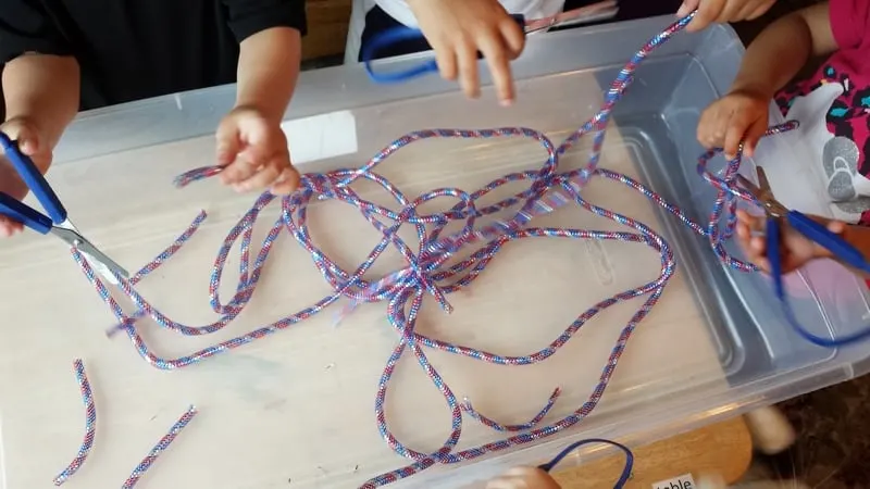 mesh tube ribbon sensory bin cutting activity 1