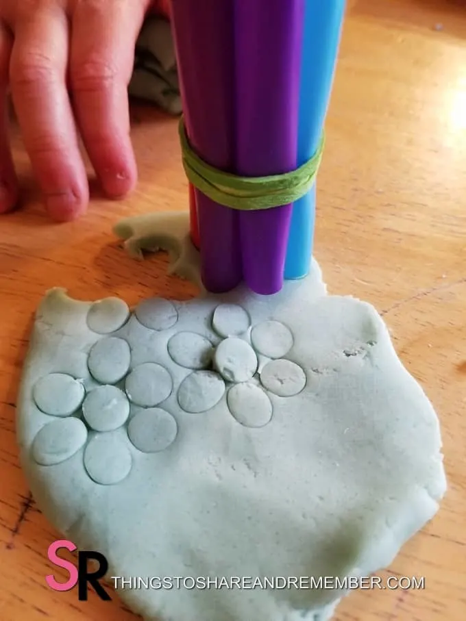 stamping play dough with straws
