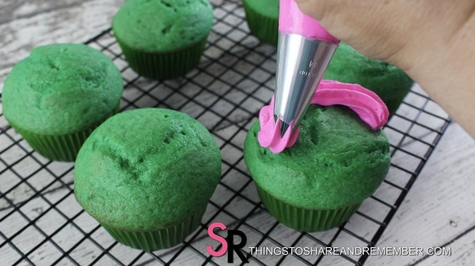 pink frosting on green cupcakes