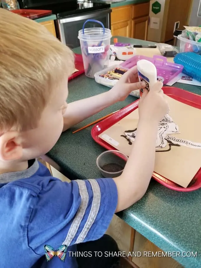Preschool Paleontologists gluing together dinosaur bones project