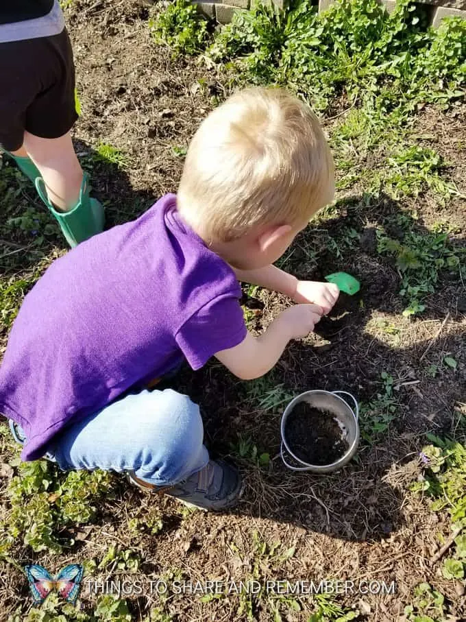 children digging in the garden for soil to make Soil Collages Creative Art