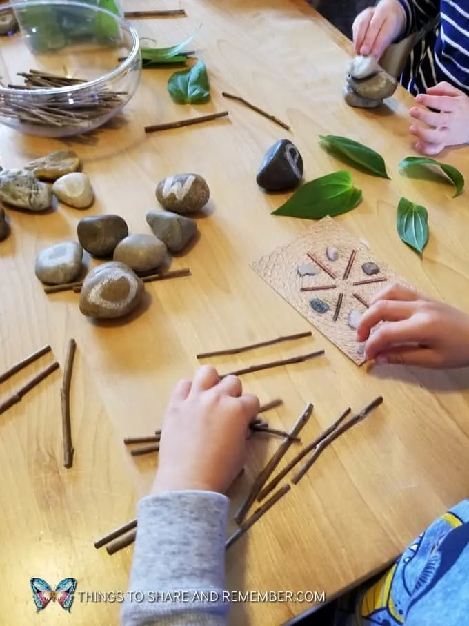 kids making Loose Parts Nature Designs with rocks, leaves and sticks