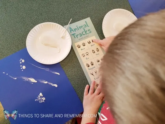 Animal Tracks art with paint and q-tips making tracks on blue paper  from Mother Goose Time Sights and Sounds #MGTblogger #MotherGooseTime #preschool #SightsandSounds 