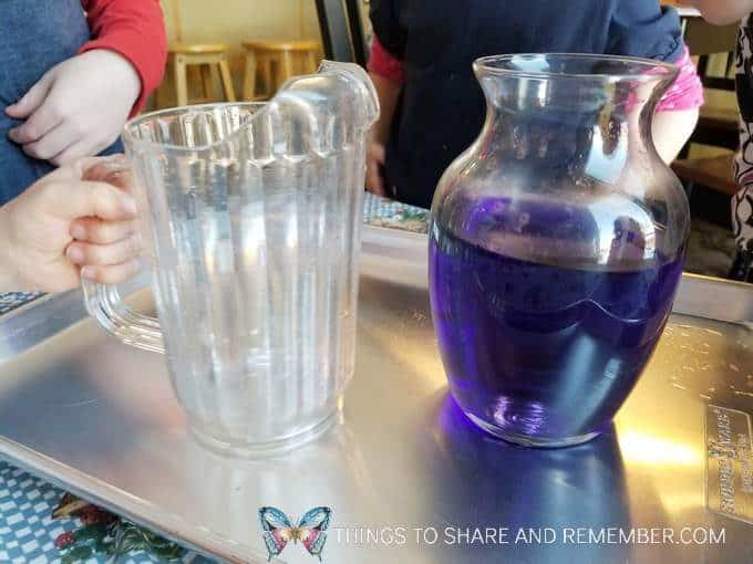 Pouring Together Community Challenge from Mother Goose Time - pouring colored water from pitcher to vase measuring and pouring preschool activities