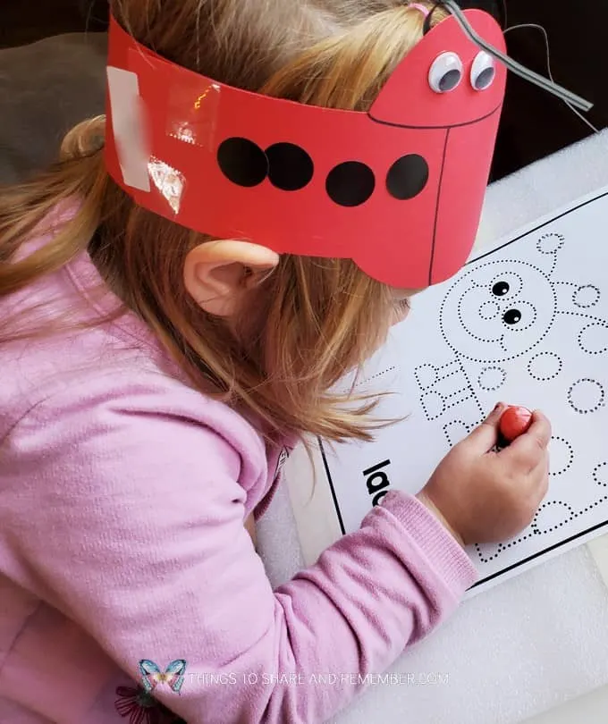 girl with ladybug headband working on ladybug art