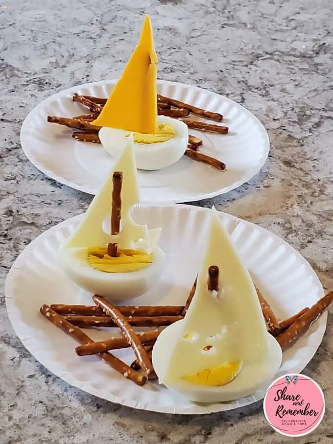 Egg Boat Snacks on a plate with pretzel sticks.