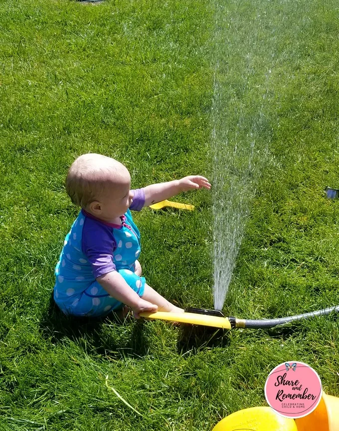 baby playing with sprinkler