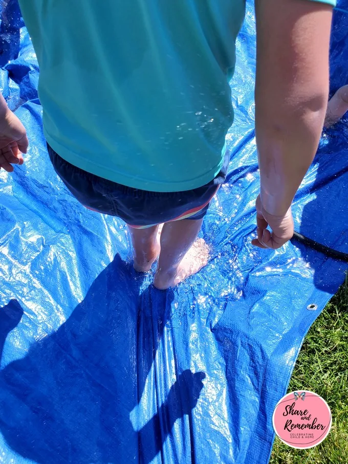 10+ Ways to Play with a Water Hose This Summer - water on a tarp
