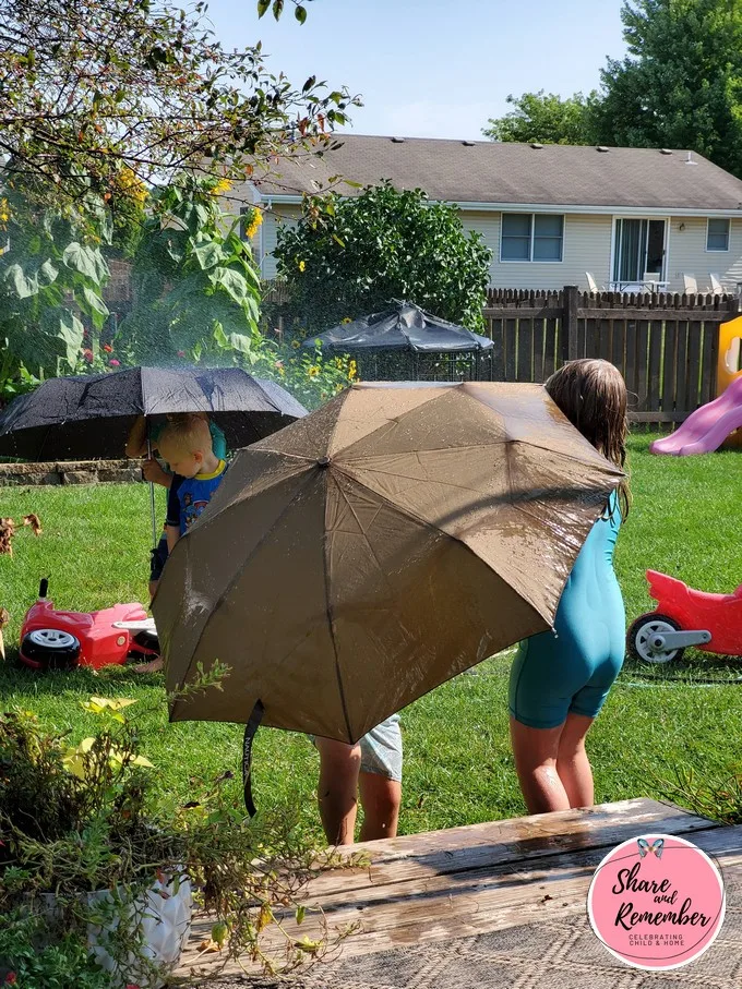 playing with umbrellas and a hose