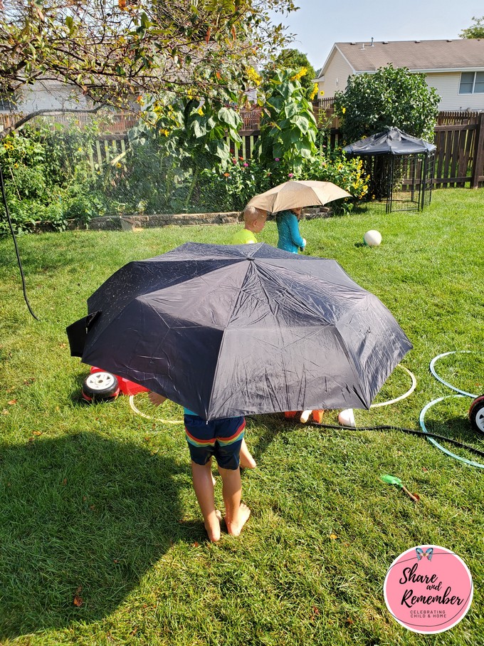playing with umbrellas and a hose