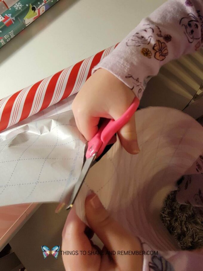 kids cutting wrapping paper and wrapping pretend presents dramatic play center